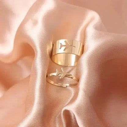Elegant gold butterfly rings for women displayed on soft satin fabric